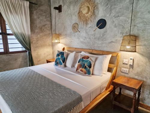 a bedroom with a bed with pillows on it at Aya Beach Resort in Kizimkazi
