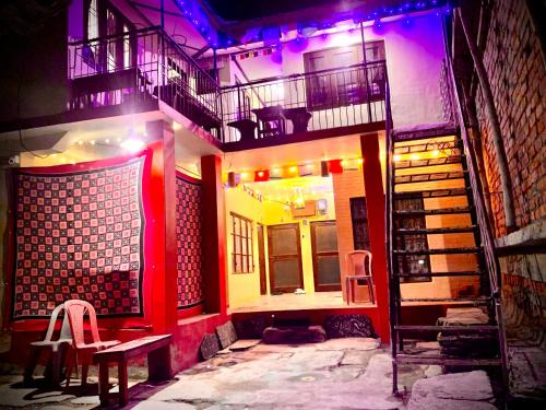 a building with a staircase and a bench in front of it at The Kashi Baba Homestay in Dharamshala