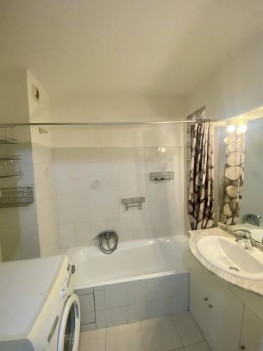 une salle de bain avec une baignoire blanche et un lavabo dans l'établissement F1 Nice Ouest, Terrasse vue mer, Wifi, à Nice