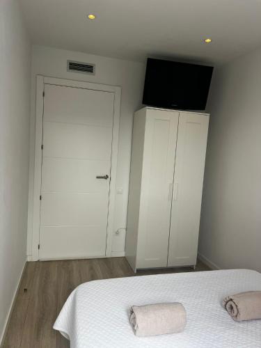 1 dormitorio con 1 cama, TV y armario en Habitación confortable para parejas, en Barcelona