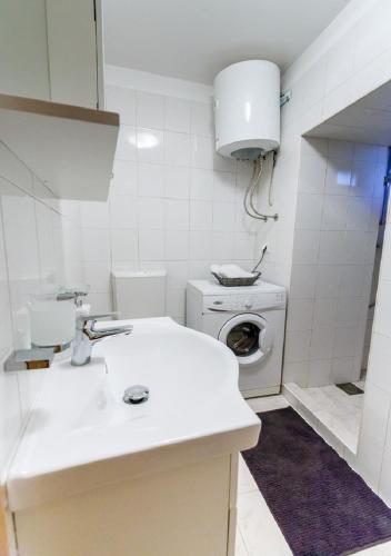 eine weiße Küche mit Waschmaschine und Spüle in der Unterkunft STUDIO APARTMAN MEMORY in Kastav