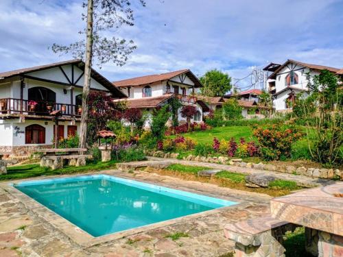 a house with a swimming pool in front of a yard at Hotel Villa de Paris in Chachapoyas
