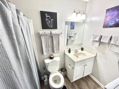 een witte badkamer met een toilet en een wastafel bij The Urban Oasis in Clarksville