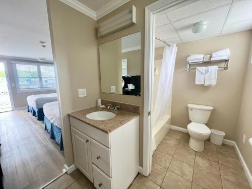 een badkamer met een wastafel, een toilet en een bed bij Cape Cod Family Resort and Parks in West Yarmouth