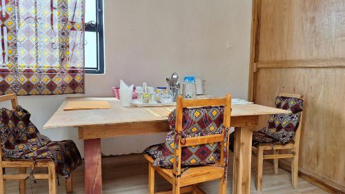 a dining room table with chairs and a wooden table at Meru Farm House in Arusha