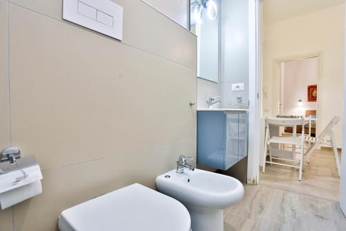 La salle de bains blanche est pourvue de toilettes et d'un lavabo. dans l'établissement Angolo Marconi Seaside Apartment, à Salerne