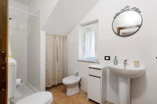 a white bathroom with a sink and a toilet at Casa Vacanze Il Torchio in Calice al Cornoviglio