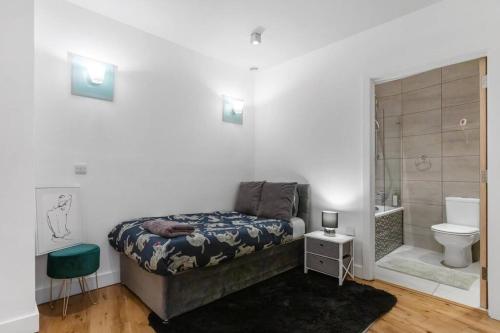 a bedroom with a bed and a bathroom with a toilet at Bank/Monument apartment in London