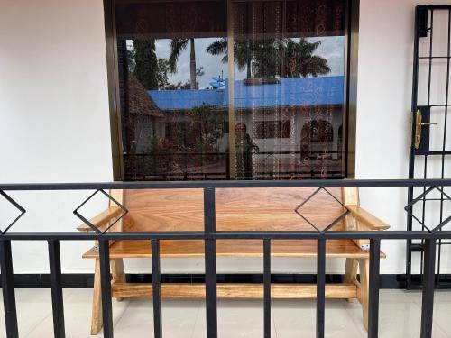 a glass table with a bench in front of a window at Kilimanjaro Trekcity Hostel in Moshi
