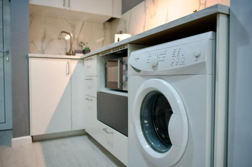 a white washer and dryer in a white kitchen at Cozy Studio Paphos in Paphos