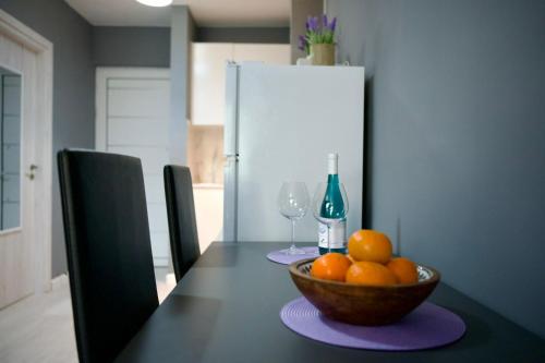 a table with a bowl of oranges and a refrigerator at Cozy Studio Paphos in Paphos