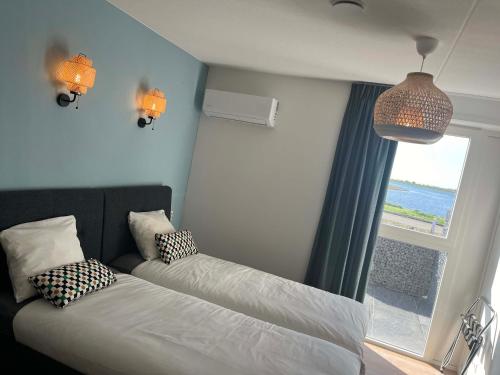 ein kleines Schlafzimmer mit einem Bett und einem Fenster in der Unterkunft Residentie Oosterschelde in Sint Philipsland