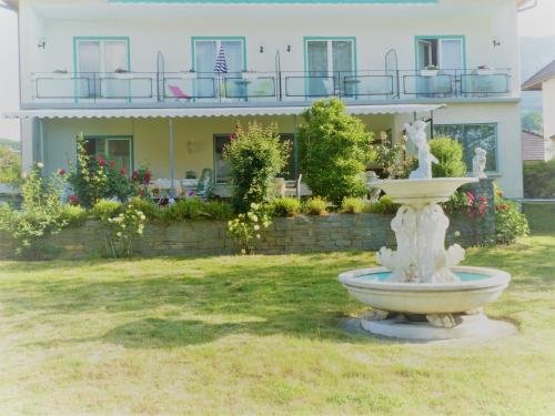 a house with a fountain in front of a building at Villa Rauter in Seeboden