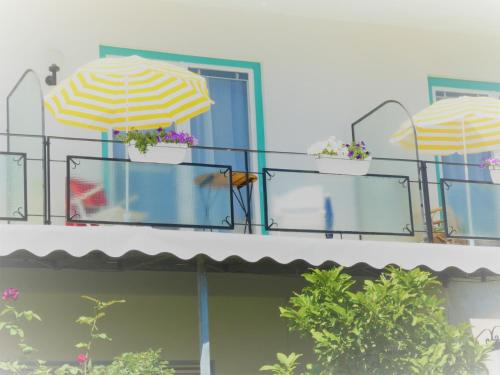 balkon z dwoma parasolami na budynku w obiekcie Villa Rauter w mieście Seeboden