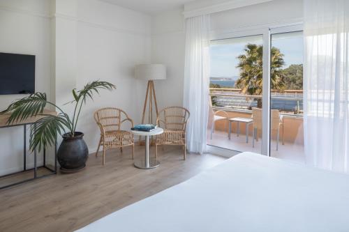 a bedroom with a bed and a table and a balcony at Hotel Sa Punta - Adults Only in Begur