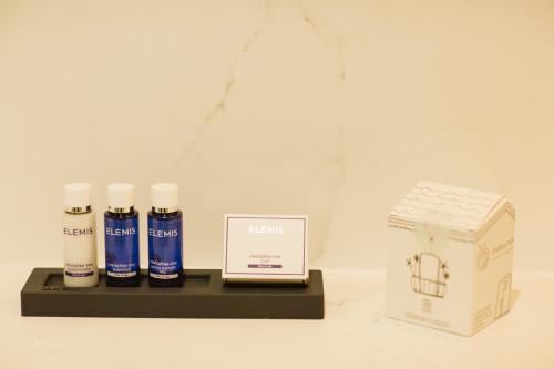 a shelf with three bottles of hair products and a box at The Hillbrook Hotel & Spa - Sherborne in Sherborne