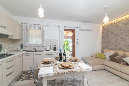 a kitchen and living room with a table and a couch at Trilo Nina in Santa Teresa Gallura