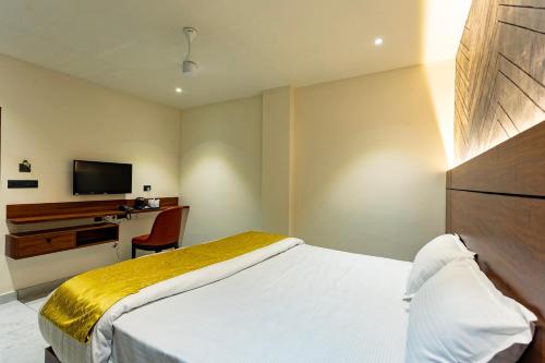 a bedroom with a bed and a desk and a television at Uphills boutique hotel in Kallar Vattiyar