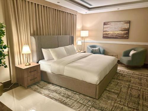 a bedroom with a large bed and a chair at Luxury apartments Alkhobar in Al Khobar
