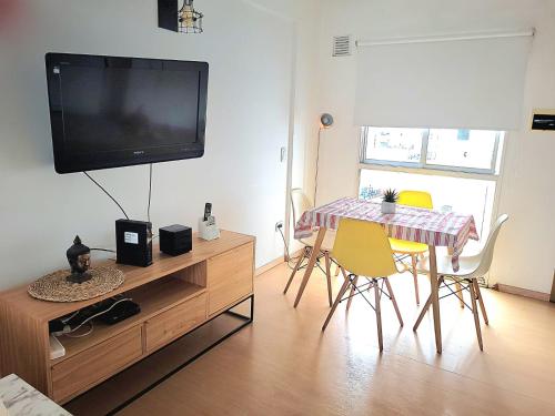 sala de estar con TV, mesa y sillas en Luminoso y cómodo departamento con balcón en Buenos Aires