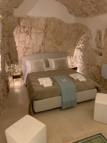 ein Schlafzimmer mit einem Bett in einer Steinmauer in der Unterkunft Cà sotto l’arco in Ostuni