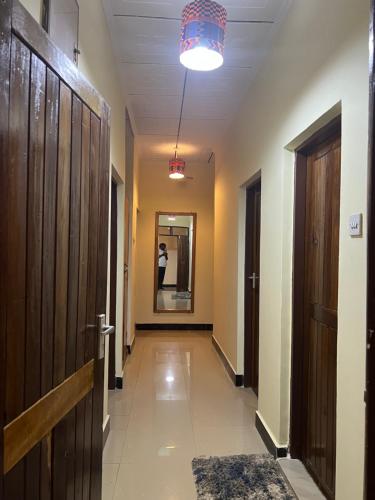 a hallway with a door and a person in the mirror at Kilimanjaro Trekcity Hostel in Moshi