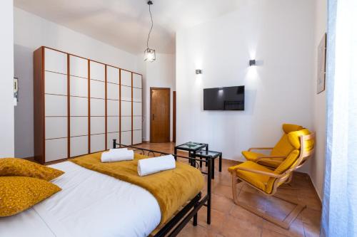 ローマにあるGianicolense Apartmentのベッドルーム1室(ベッド1台、黄色い椅子付)