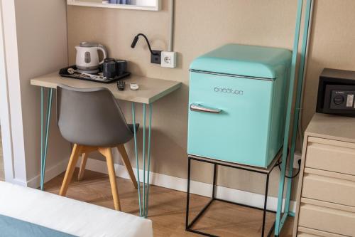 a small kitchen with a blue refrigerator next to a table at Regina Selfcheck-in Smart Rooms in Palma de Mallorca