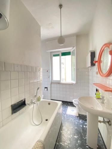 a white bathroom with a tub and a sink at ‘La Casa di Rosa’ in Levanto