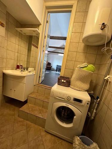 een badkamer met een wasmachine en een wastafel bij Lite hus til leie sommeren 2024 in Arendal