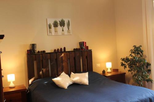 a bedroom with a blue bed with two pillows at Tenuta SGB - Il profumo del vino Etna Nicolosi in Nicolosi