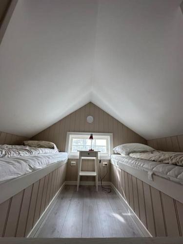 een kamer met 2 bedden en een bureau op zolder bij Lite hus til leie sommeren 2024 in Arendal