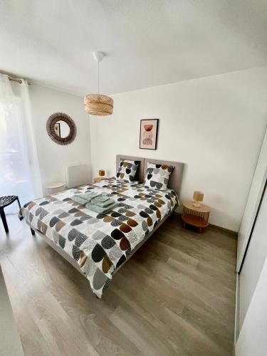 une chambre avec un lit avec une couette noire et blanche dans l'établissement Appart Cosy 6 personnes, à Floirac