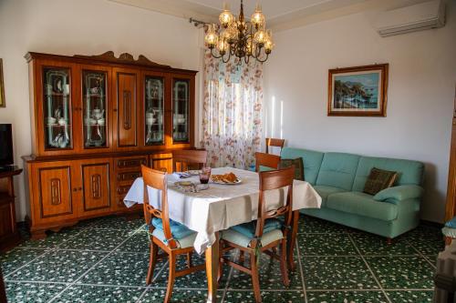 a dining room with a table and a couch at Appartamento IL LIMONE zona centrale vista mare in San Vincenzo
