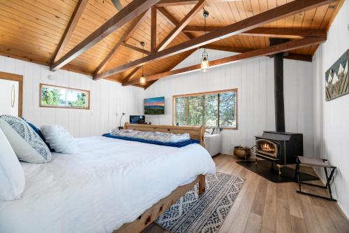1 dormitorio con 1 cama grande y chimenea en WINTERFELL LAKEVIEW - EV Charger - Walk to Slopes/Lake, en Big Bear Lake