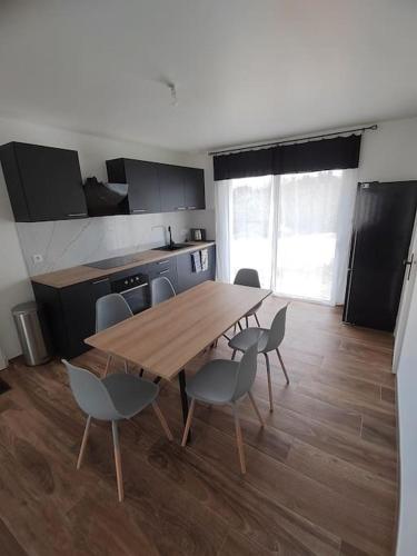 a kitchen with a wooden table and chairs in a room at Maison individuelle, à 5 km du Puy du Fou in Chambretaud