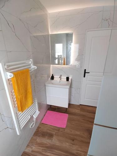 une salle de bain blanche avec un lavabo et un miroir dans l'établissement Maison individuelle, à 5 km du Puy du Fou, à Chambretaud