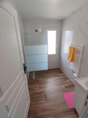 une salle de bain blanche avec une douche et un lavabo dans l'établissement Maison individuelle, à 5 km du Puy du Fou, à Chambretaud