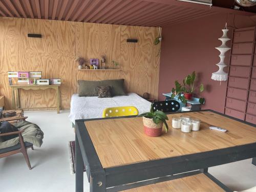 ein Schlafzimmer mit einem Bett und einem Holztisch in der Unterkunft Magnifique studio indépendant in Collonges-au-Mont-dʼOr