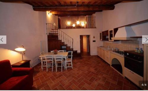 a kitchen and a dining room with a table in a room at LA CASA DEL CALZOLAIO in Radicofani