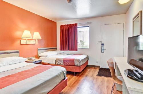 a hotel room with two beds and a flat screen tv at Motel 6-Pittsburgh, PA - Crafton in Pittsburgh