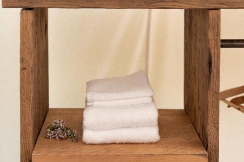 a stack of towels sitting on a wooden shelf at Homegrown Hideaway in Port Dover