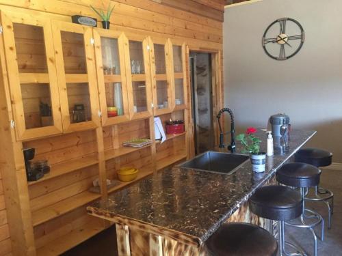 cocina con encimera con fregadero y taburetes en Ponderosa Inn en Escalante