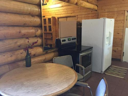 a kitchen with a table and a refrigerator and a table and chairs at Ponderosa Inn in Escalante