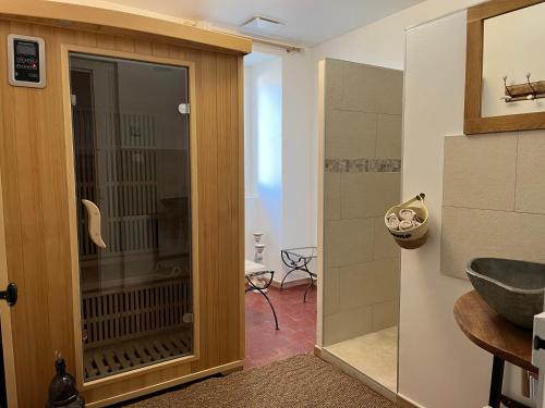 a bathroom with a shower and a glass door at Les Dames de Saint Florent in Saint-Florent-sur-Auzonnet