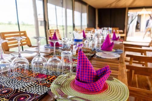 a table with pink party hats on top of it at Serengeti Malaika Luxury Camp in Serengeti National Park