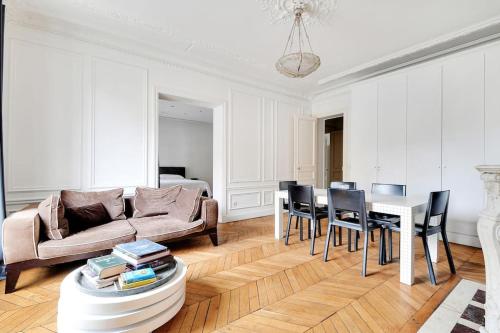 un salon avec un canapé, une table et des chaises dans l'établissement Charme au Cœur de Paris, à Paris