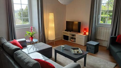 uma sala de estar com um sofá e uma televisão em Maison de 2 chambres avec jardin clos et wifi a Martisserre em Martisserre