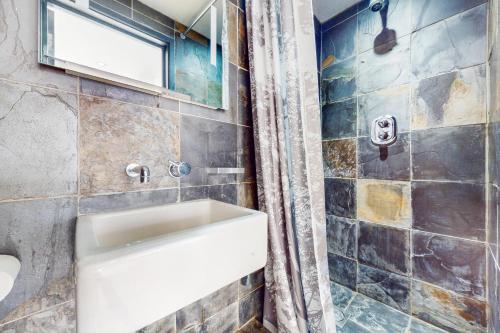 een badkamer met een wastafel en een douche bij 1 Bed Maisonette with Garden - 1 min to station Share Save in Londen