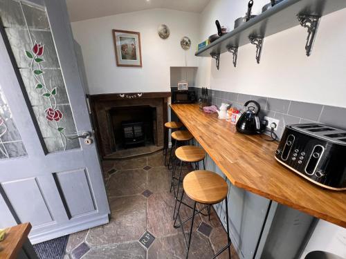 a kitchen with a counter and stools in a room at RB Contractor Stays - Ty Capel in Pwllheli